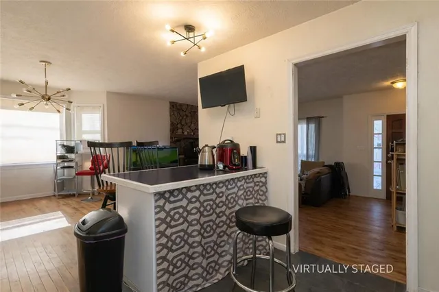 a kitchen with stainless steel appliances kitchen island granite countertop a stove and a flat screen tv
