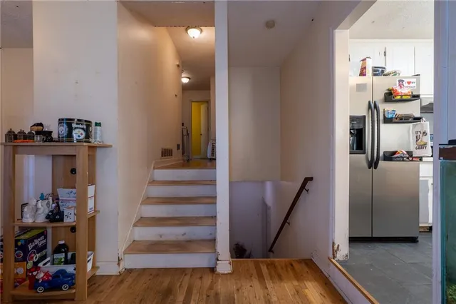 a view of a hallway with wooden floor and workspace