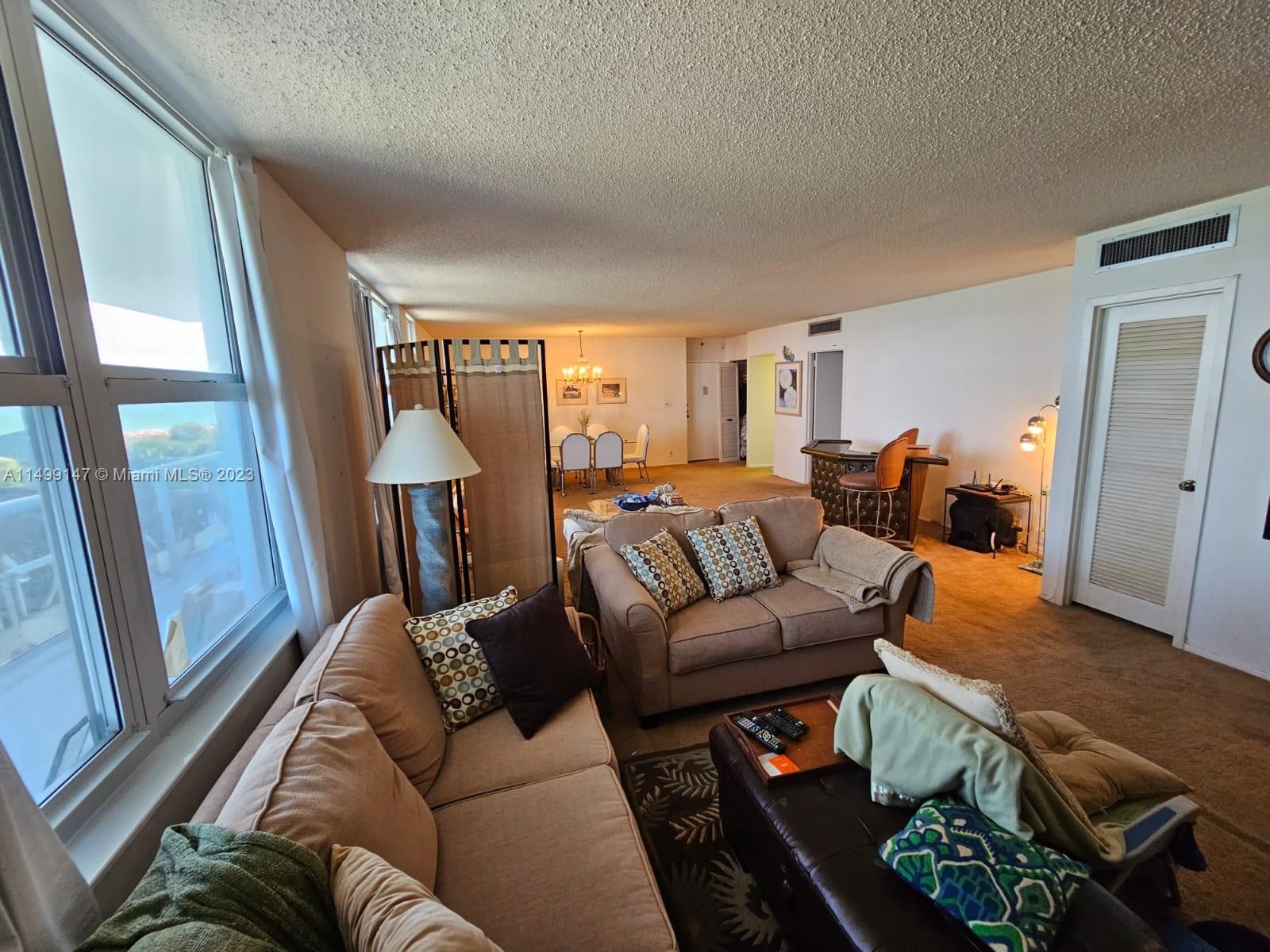 9511 Collins Avenue, Unit 403 Surfside, FL 33154 - Photo 13 of 52 a living room with furniture and a large window