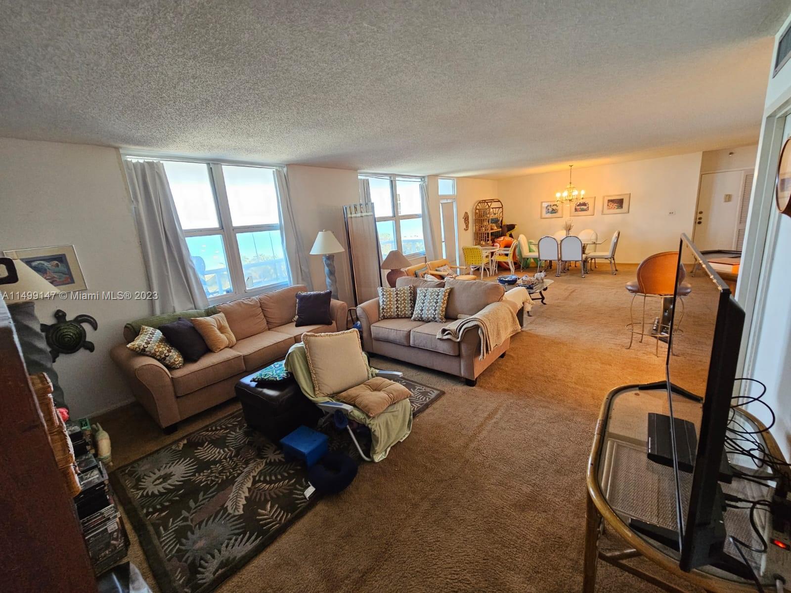 9511 Collins Avenue, Unit 403 Surfside, FL 33154 - Photo 14 of 52 a living room with furniture and a floor to ceiling window