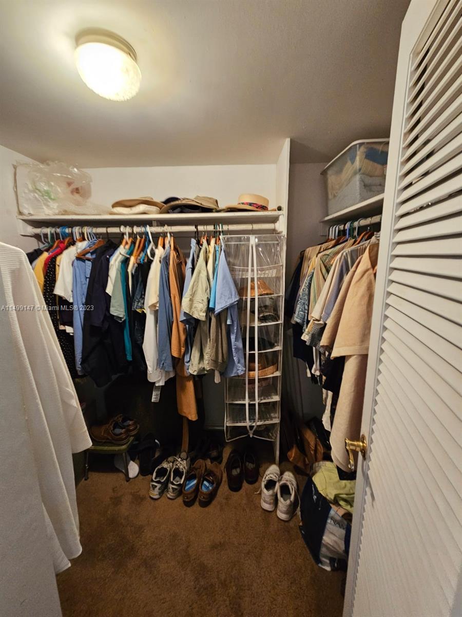 9511 Collins Avenue, Unit 403 Surfside, FL 33154 - Photo 29 of 52 a view of walk in closet with clothes and shoes