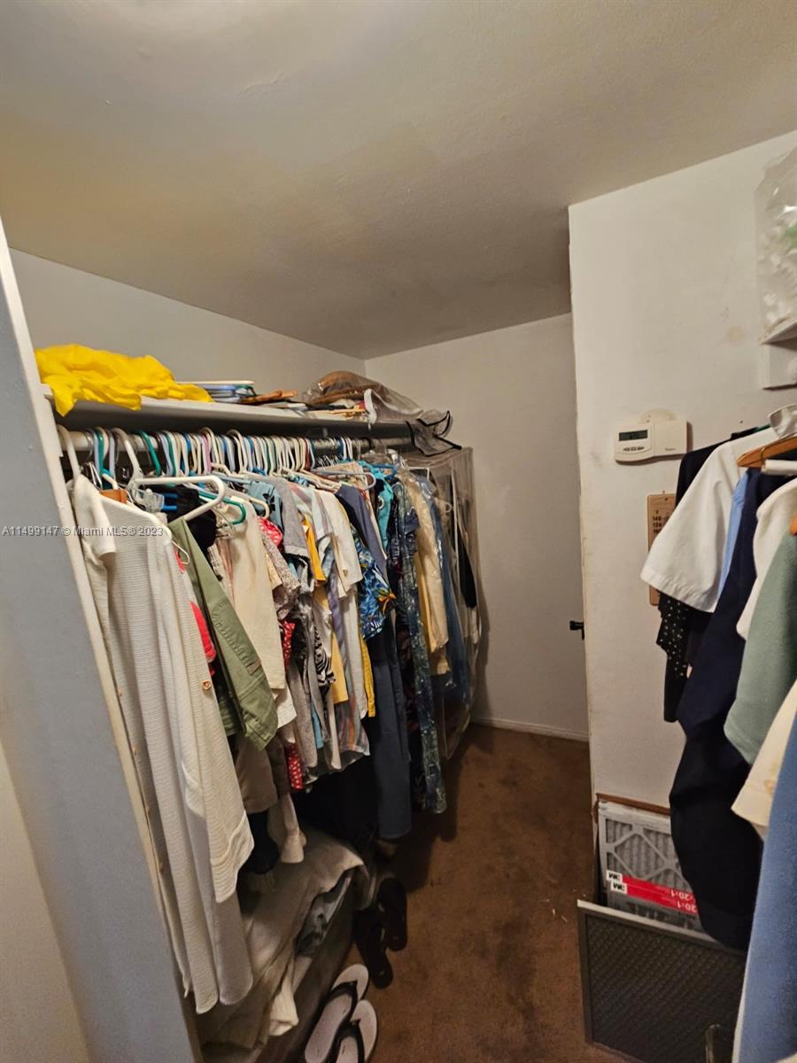 9511 Collins Avenue, Unit 403 Surfside, FL 33154 - Photo 30 of 52 a view of walk in closet with clothes and shoes