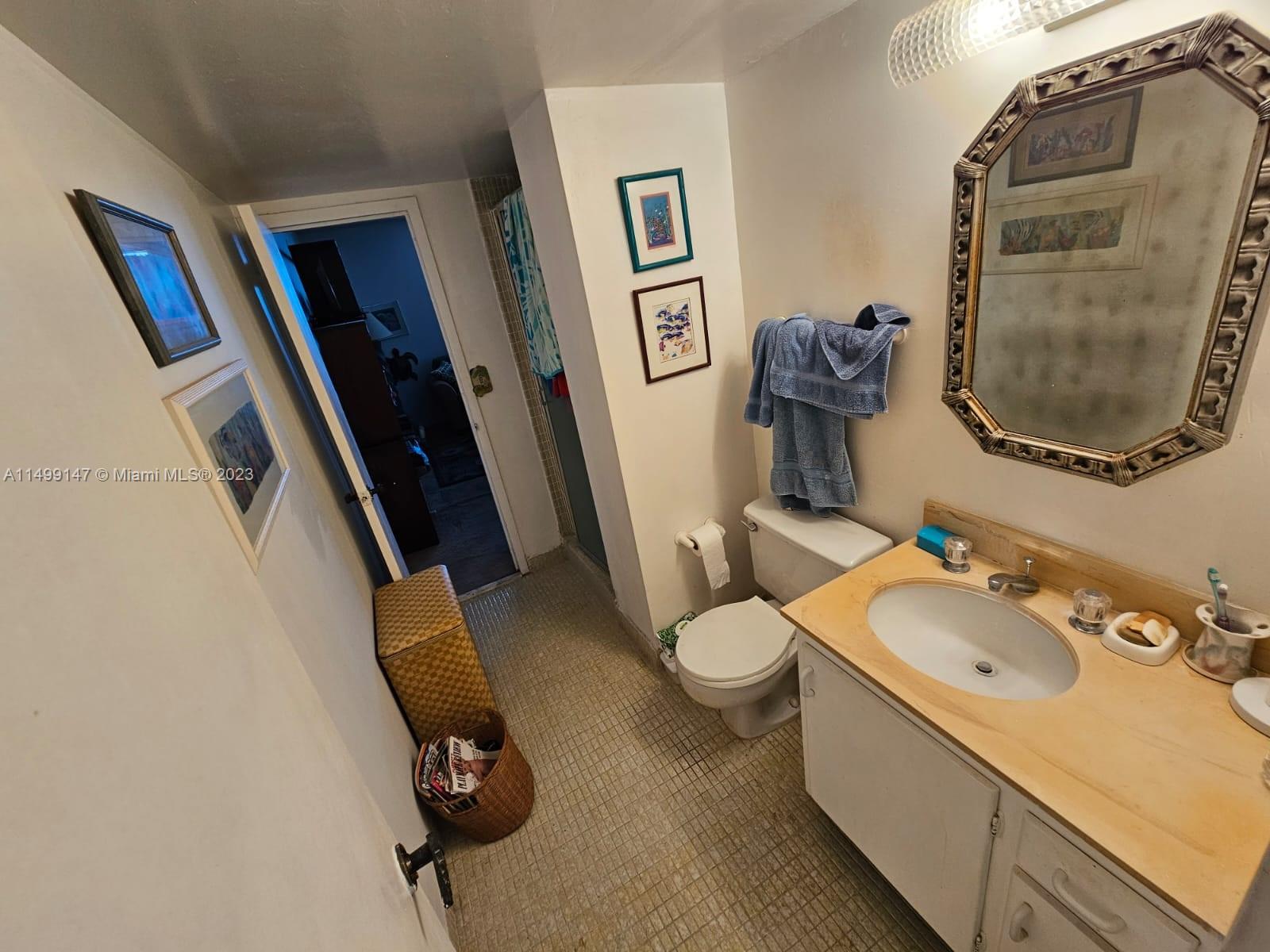 9511 Collins Avenue, Unit 403 Surfside, FL 33154 - Photo 41 of 52 a bathroom with a sink and a mirror