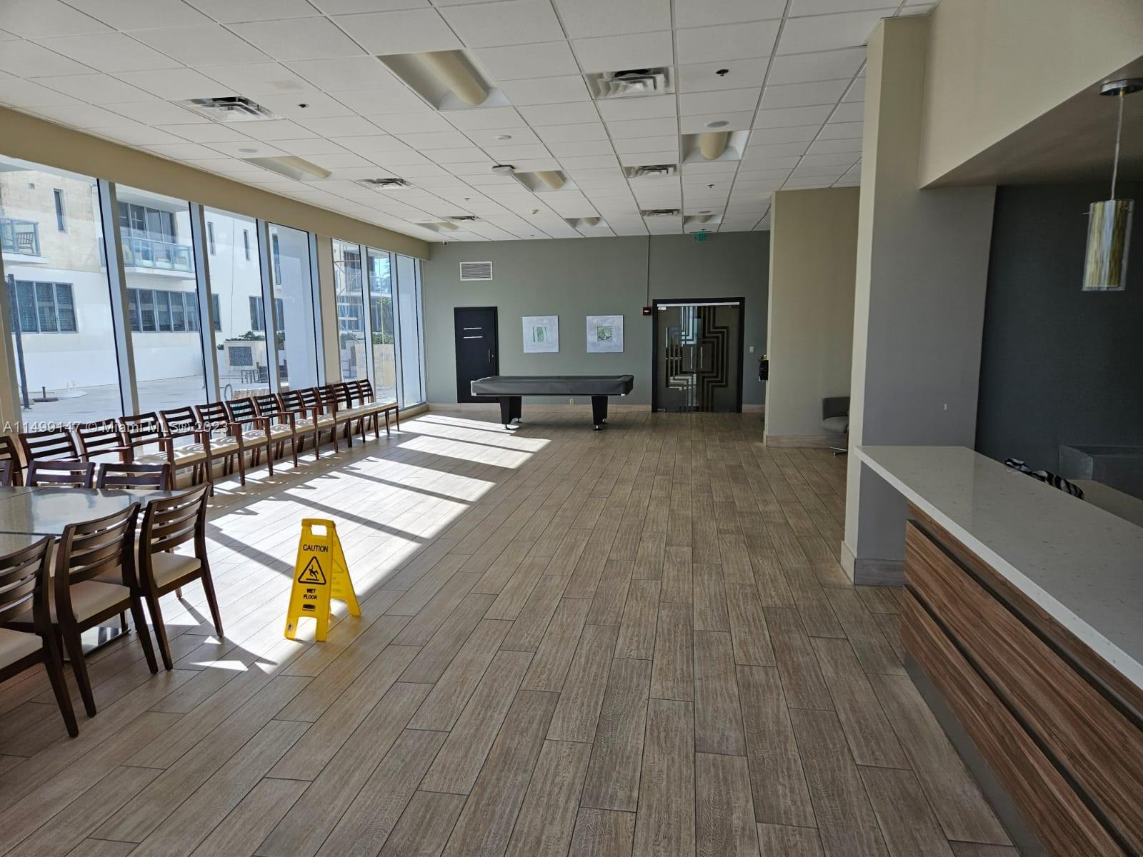 9511 Collins Avenue, Unit 403 Surfside, FL 33154 - Photo 44 of 52 a large hall with chairs and wooden floor