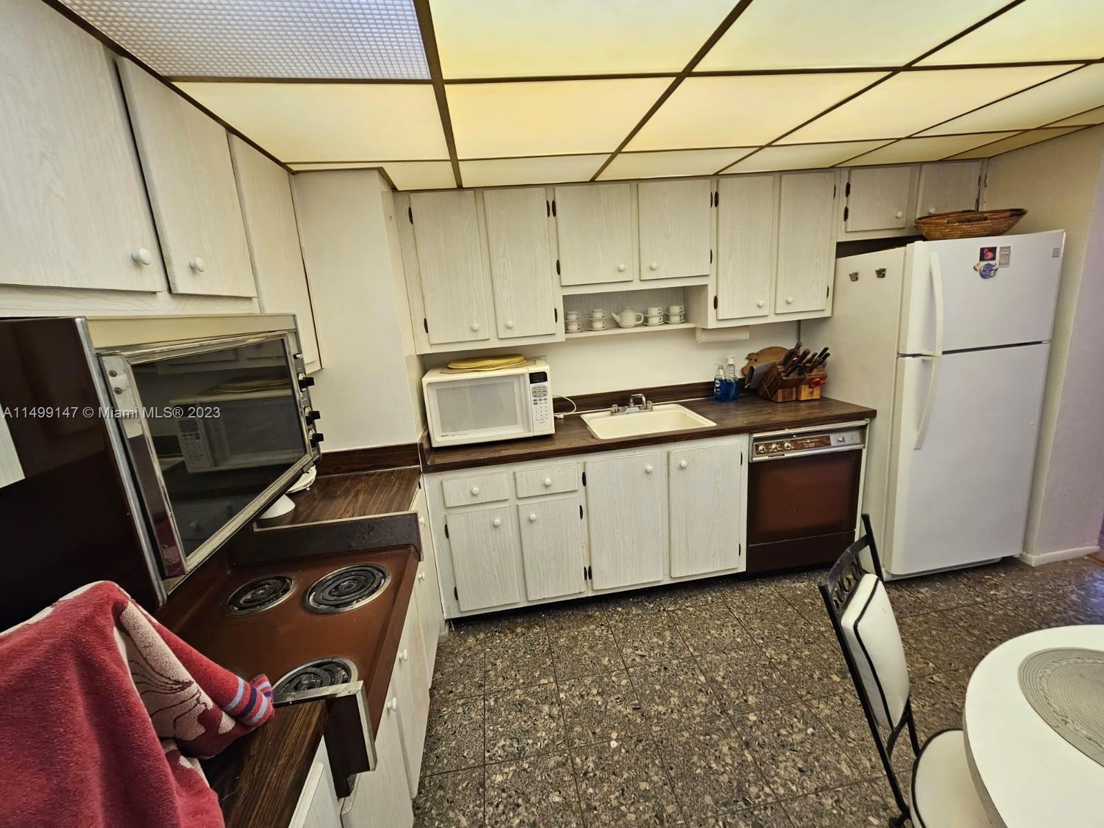 9511 Collins Avenue, Unit 403 Surfside, FL 33154 - Photo 5 of 52 a kitchen with a sink appliances and cabinets