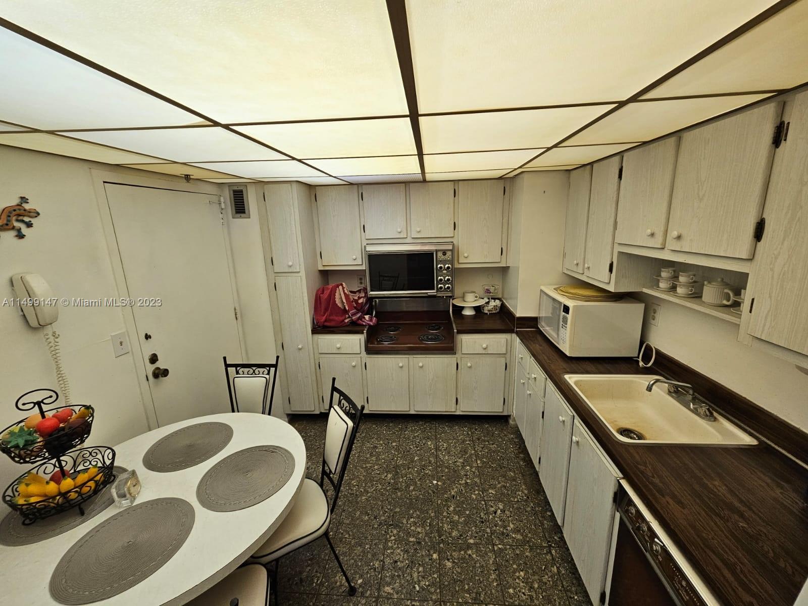 9511 Collins Avenue, Unit 403 Surfside, FL 33154 - Photo 6 of 52 a kitchen with furniture a sink and a stove