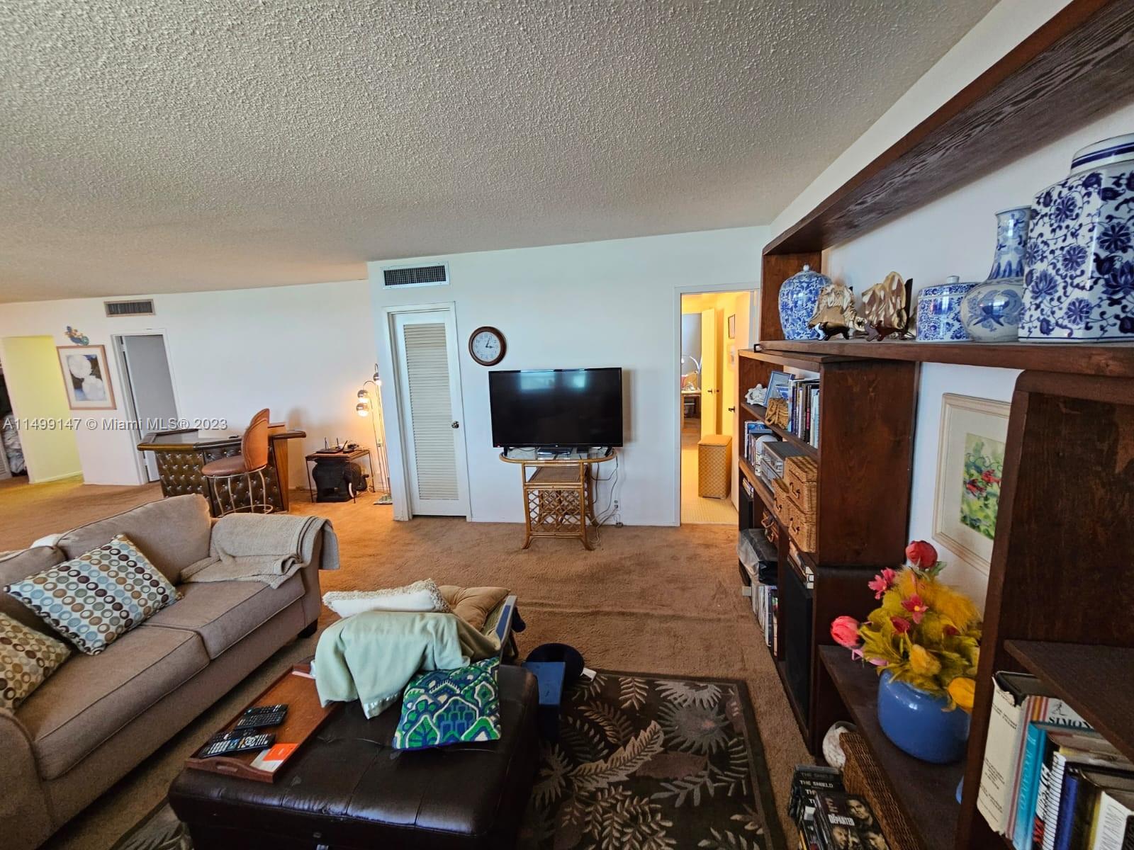 9511 Collins Avenue, Unit 403 Surfside, FL 33154 - Photo 9 of 52 a living room with furniture a flat screen tv and a couch