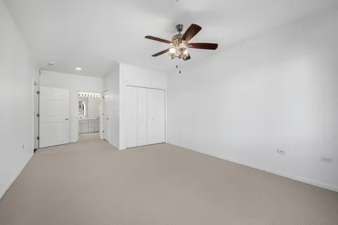 an empty room with a ceiling fan and window