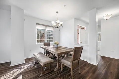 a dining room with furniture a chandelier and wooden floor