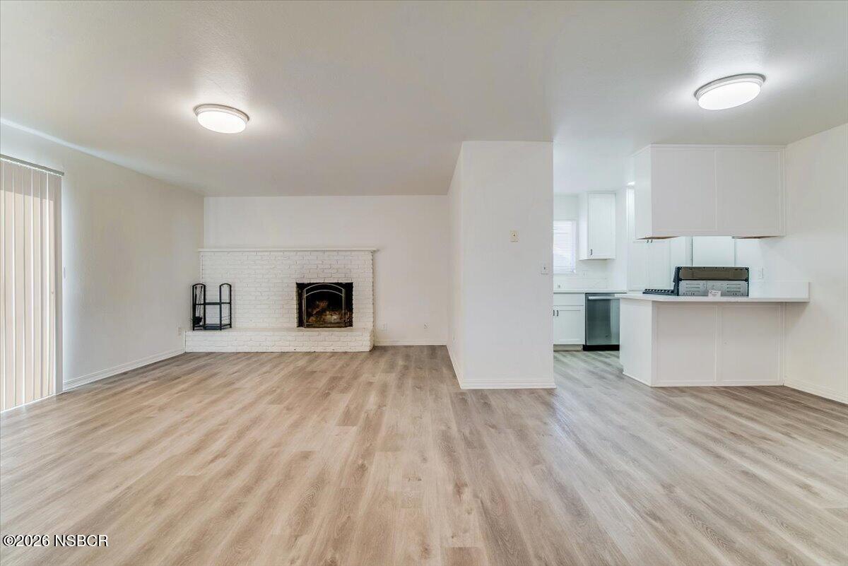 321 North Z Street Lompoc, CA 93436 - Photo 8 of 33 a view of empty room with wooden floor and kitchen