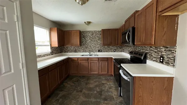 a kitchen with a sink stove and cabinets