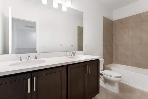 a bathroom with a double vanity sink mirror and shower