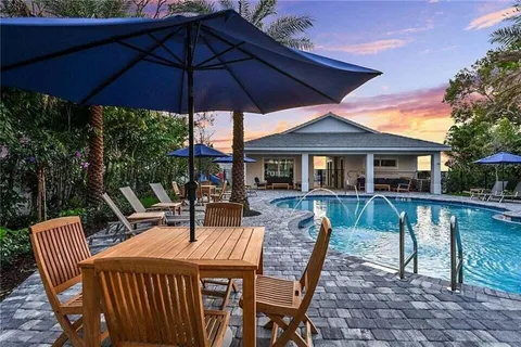 a patio with a table and chairs under an umbrella