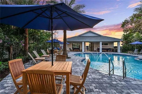 a patio with a table and chairs under an umbrella
