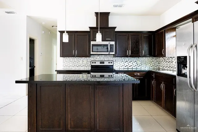 a kitchen with stainless steel appliances granite countertop a stove and a refrigerator
