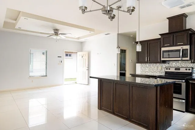 a kitchen with stainless steel appliances granite countertop a sink a stove and a refrigerator