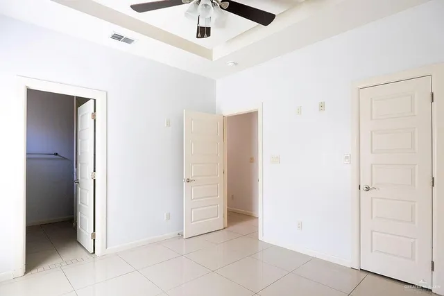 an empty room with closet and fan
