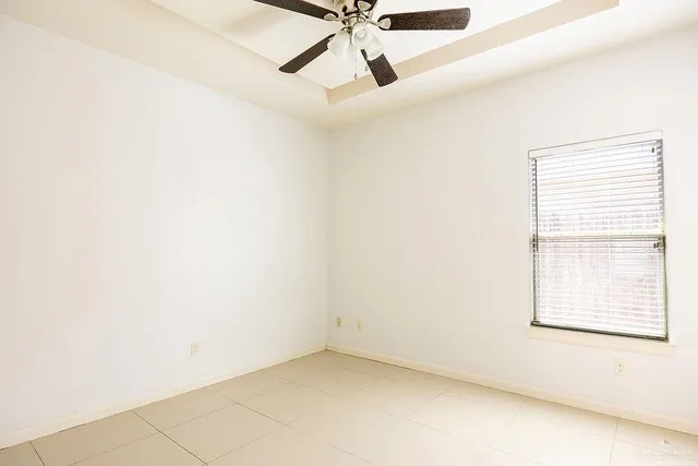 an empty room with a window and a fan