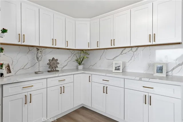 a kitchen with white cabinets and sink