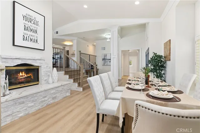 a dining room with furniture a fireplace and wooden floor