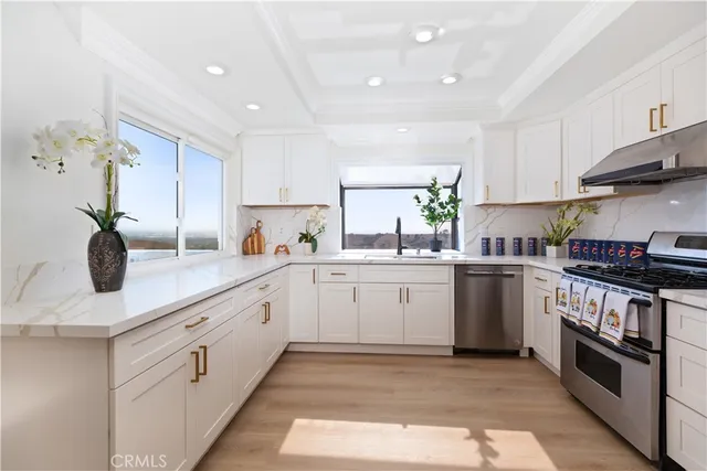 a kitchen with white cabinets and appliances