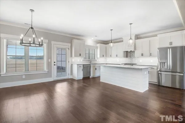 a kitchen with white cabinets stainless steel appliances and wooden floor