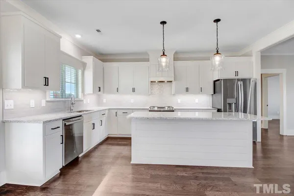 a kitchen with stainless steel appliances granite countertop a sink stove and refrigerator