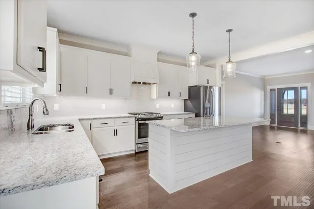 a view of a kitchen island a chandelier and wooden floor