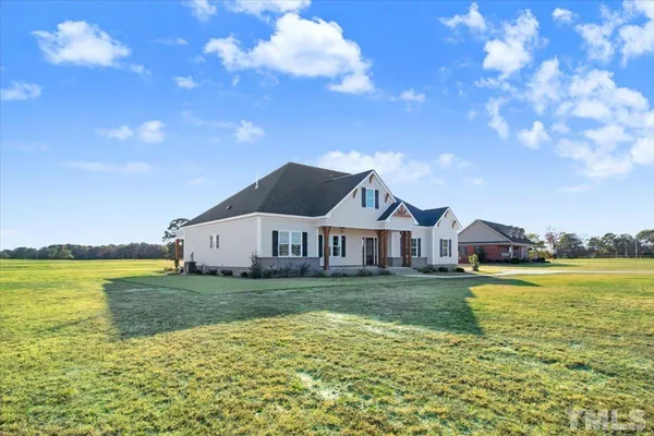 a view of a big house with a big yard and a large tree