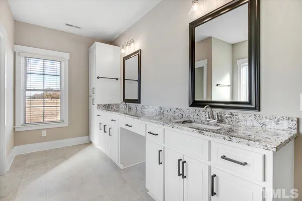 a bathroom with a double vanity sink and mirror
