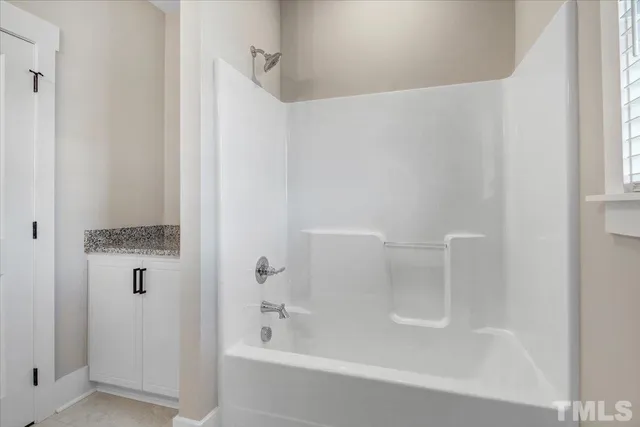 a view of an empty room with a ceiling fan and a window