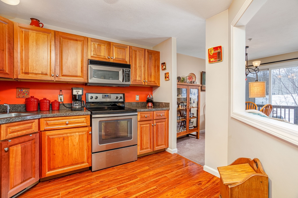 101 Bridle Cross Road, Unit 101 Fitchburg, MA 01420 - Photo 11 of 26 a kitchen with stainless steel appliances granite countertop a refrigerator and a stove top oven