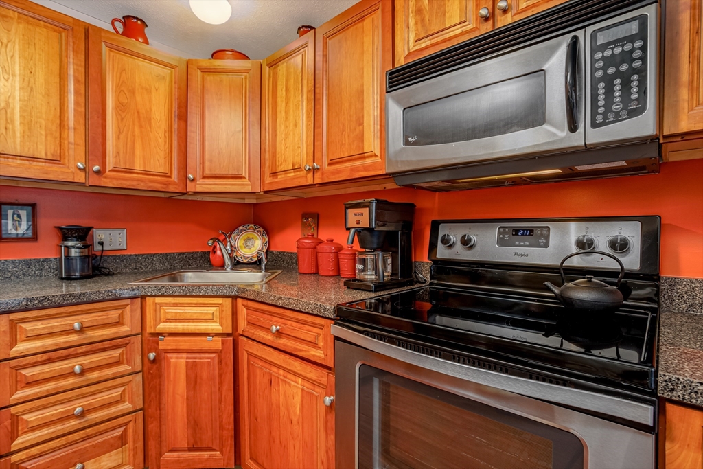 101 Bridle Cross Road, Unit 101 Fitchburg, MA 01420 - Photo 13 of 26 a kitchen with stainless steel appliances granite countertop a stove and a microwave