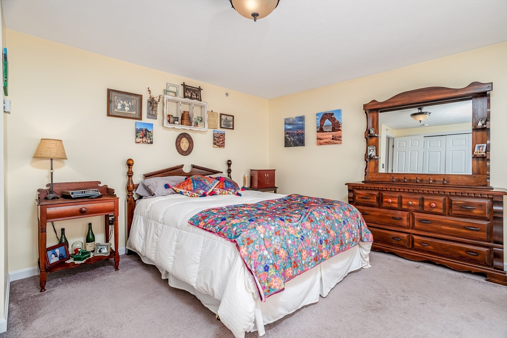 101 Bridle Cross Road, Unit 101 Fitchburg, MA 01420 - Photo 16 of 26 a bedroom with a bed and a chandelier