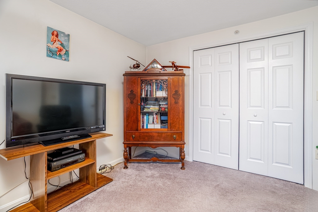 101 Bridle Cross Road, Unit 101 Fitchburg, MA 01420 - Photo 20 of 26 a room with furniture and flat screen tv