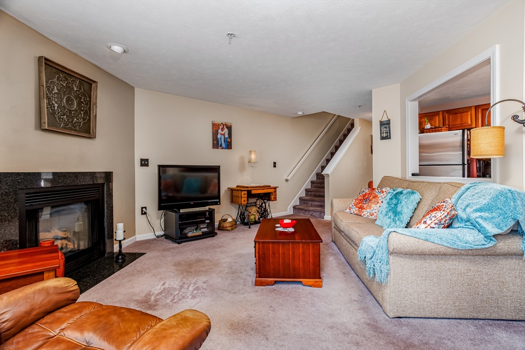 101 Bridle Cross Road, Unit 101 Fitchburg, MA 01420 - Photo 7 of 26 a living room with furniture and a fireplace