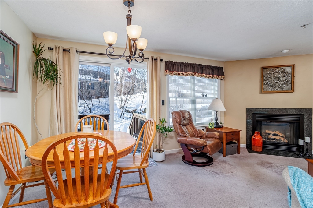 101 Bridle Cross Road, Unit 101 Fitchburg, MA 01420 - Photo 9 of 26 a living room with furniture a fireplace and a floor to ceiling window