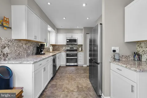 a kitchen with kitchen island granite countertop a stove sink and refrigerator