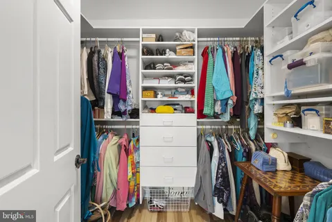 a view of walk in closet with clothes and shoes