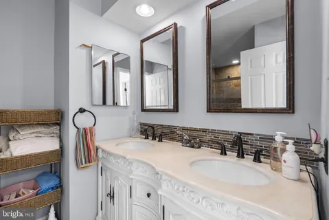 a bathroom with double vanity sinks and a mirror