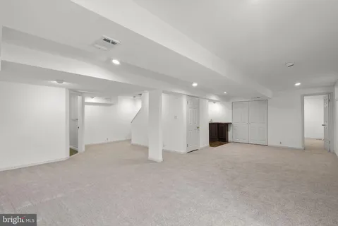 an empty room with kitchen view and a window