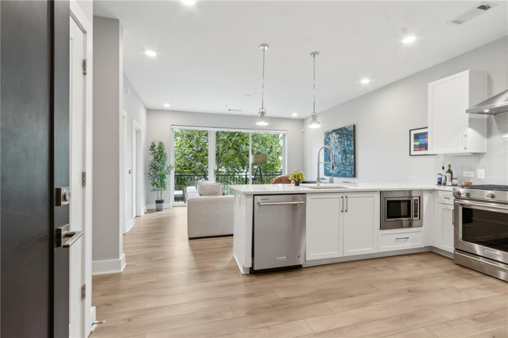 22 Airline Street Southeast, Unit 204 Atlanta, GA 30312 - Photo 5 of 34 a large white kitchen with a large window a sink and stainless steel appliances