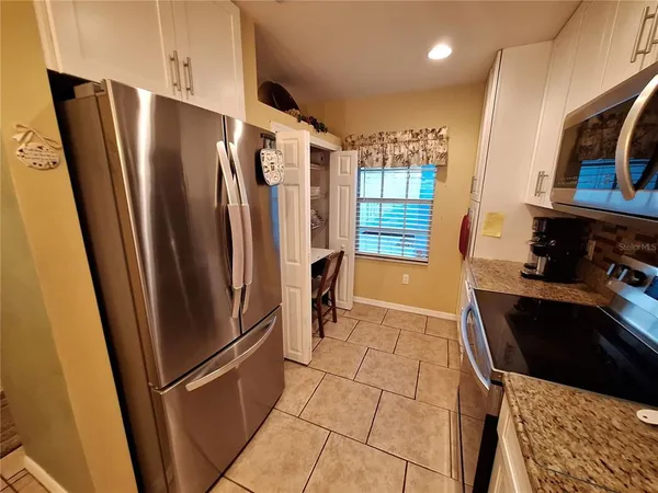a kitchen with stainless steel appliances granite countertop a refrigerator and a stove top oven