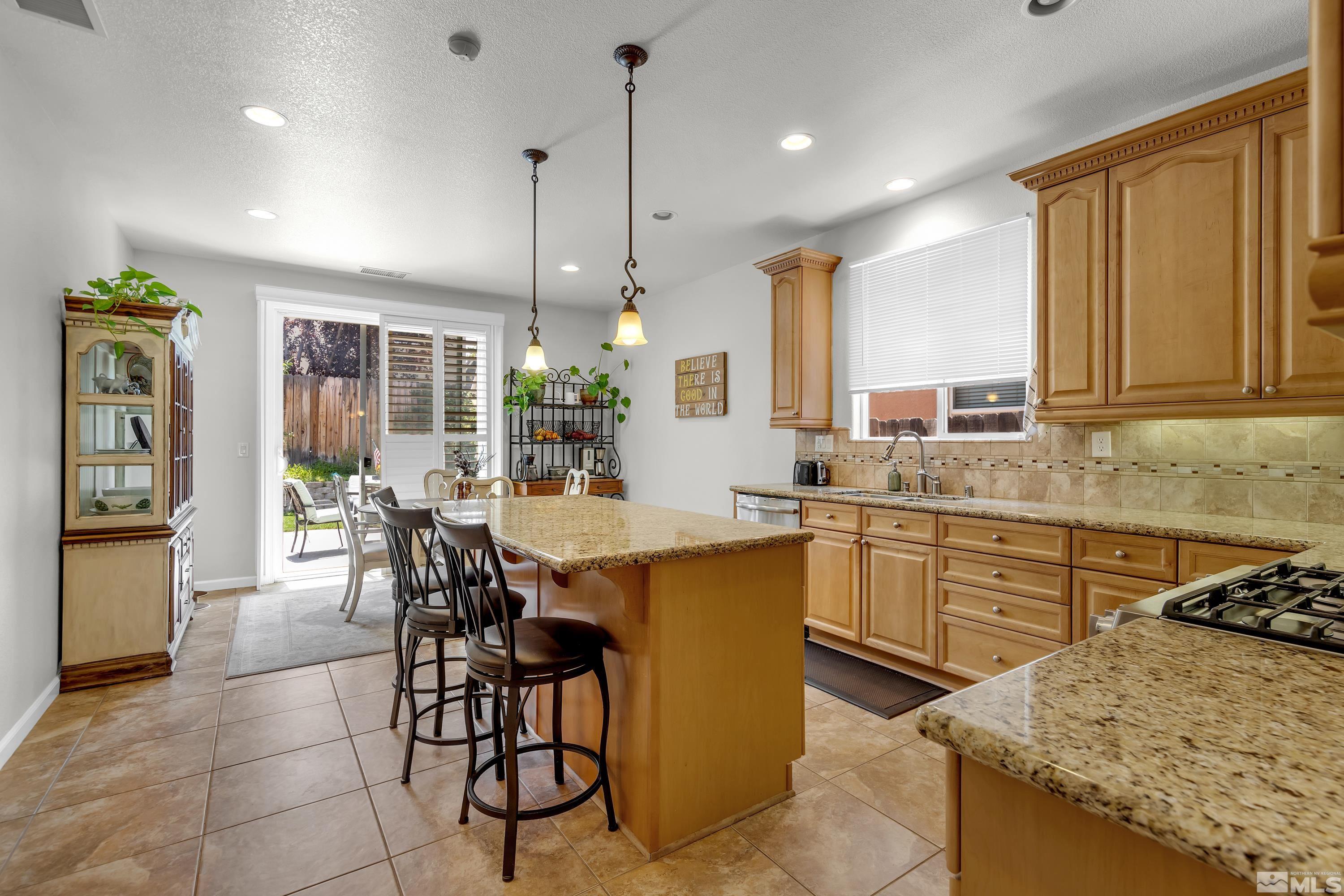 2100 Angel Ridge Drive Reno, NV 89521 - Photo 2 of 35 a kitchen with a table chairs microwave and cabinets