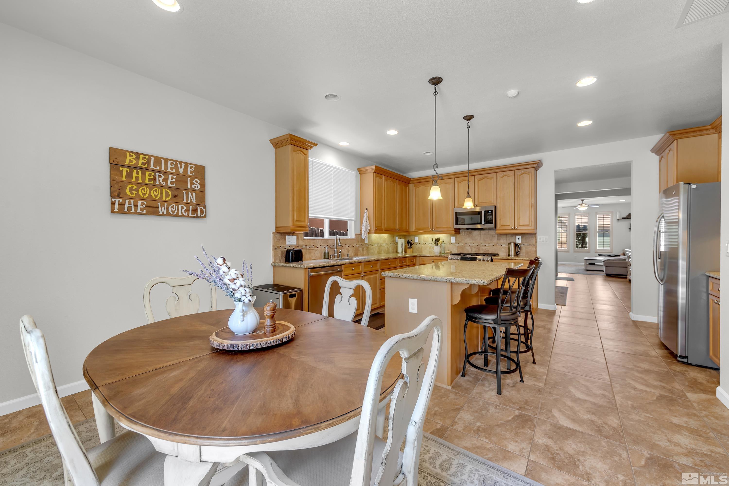 2100 Angel Ridge Drive Reno, NV 89521 - Photo 35 of 35 a kitchen with stainless steel appliances kitchen island granite countertop a dining table chairs and a refrigerator