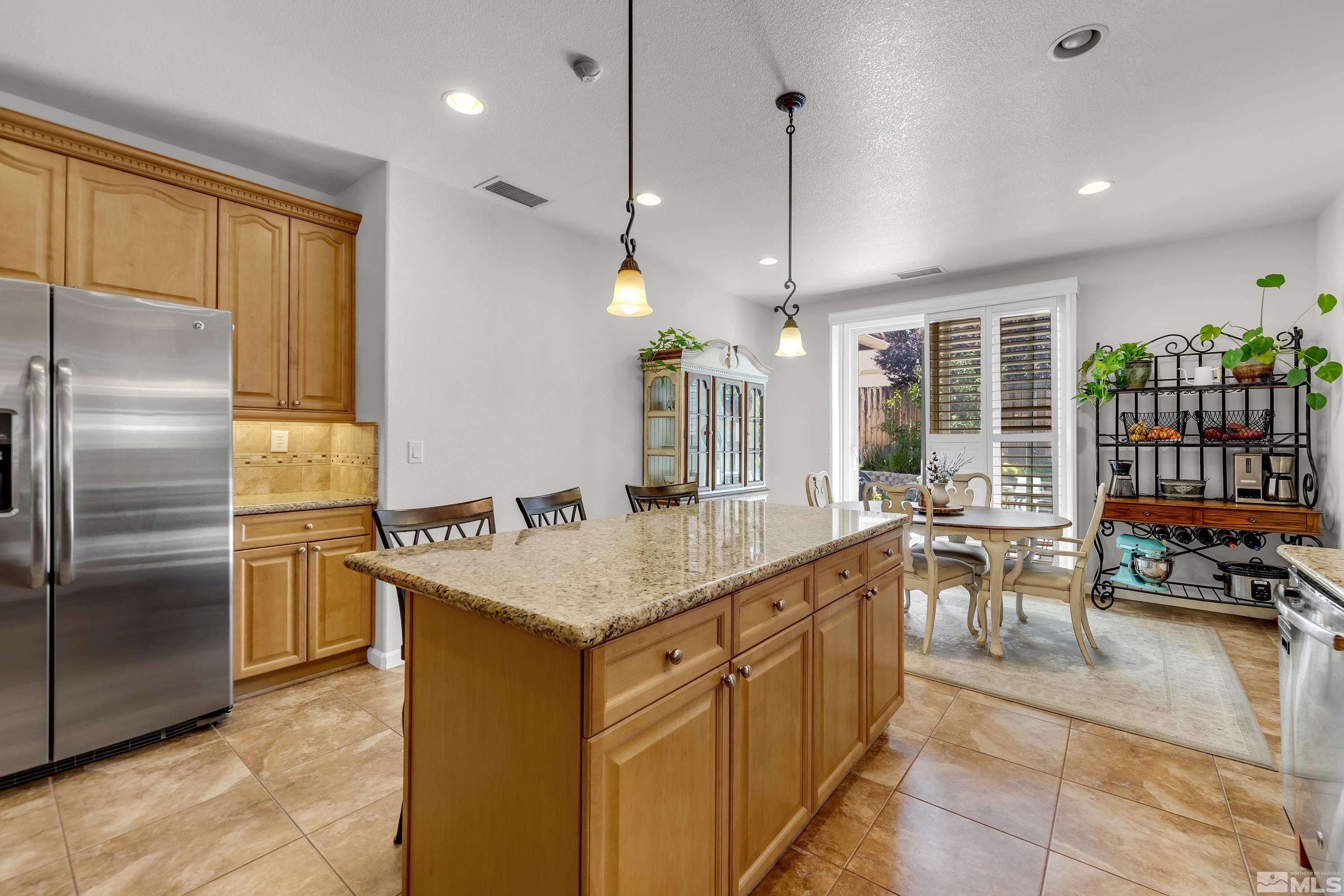 2100 Angel Ridge Drive Reno, NV 89521 - Photo 9 of 35 a kitchen with stainless steel appliances granite countertop a sink a stove and a refrigerator