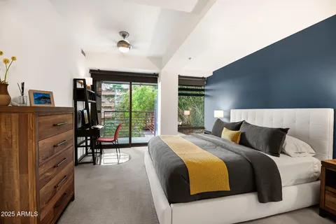 a bedroom with a bed and large windows