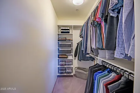 a view of walk in closet with clothes and shoes