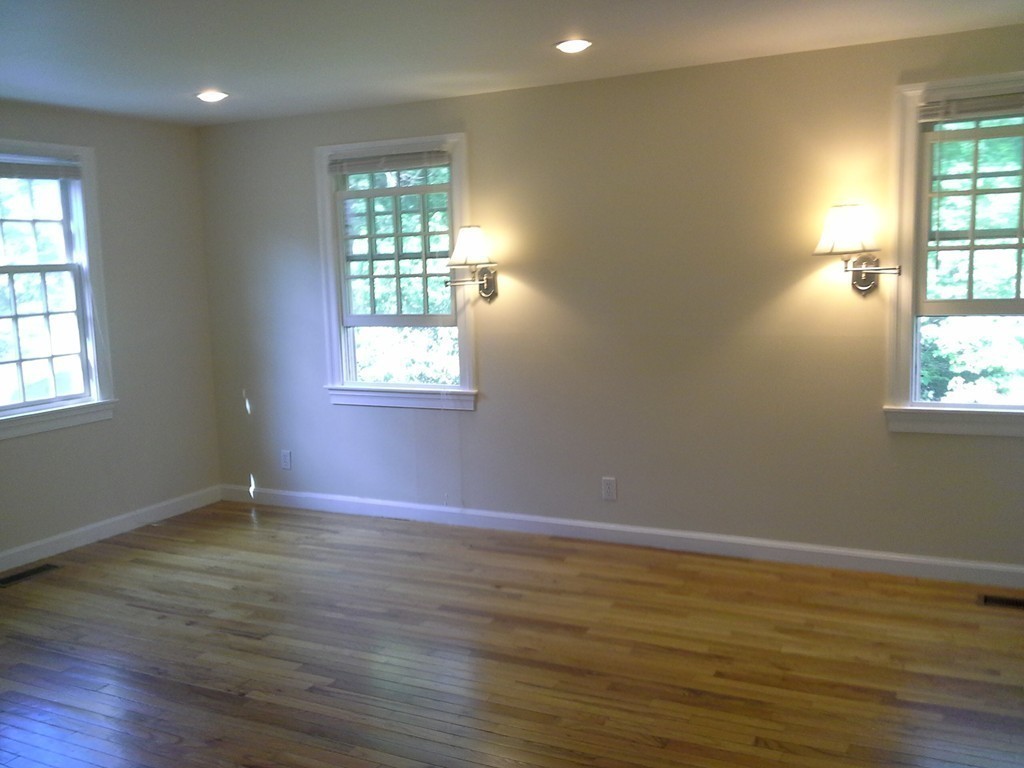 123 Jericho Road, Unit 123 Weston, MA 02493 - Photo 7 of 12 an empty room with wooden floor and windows