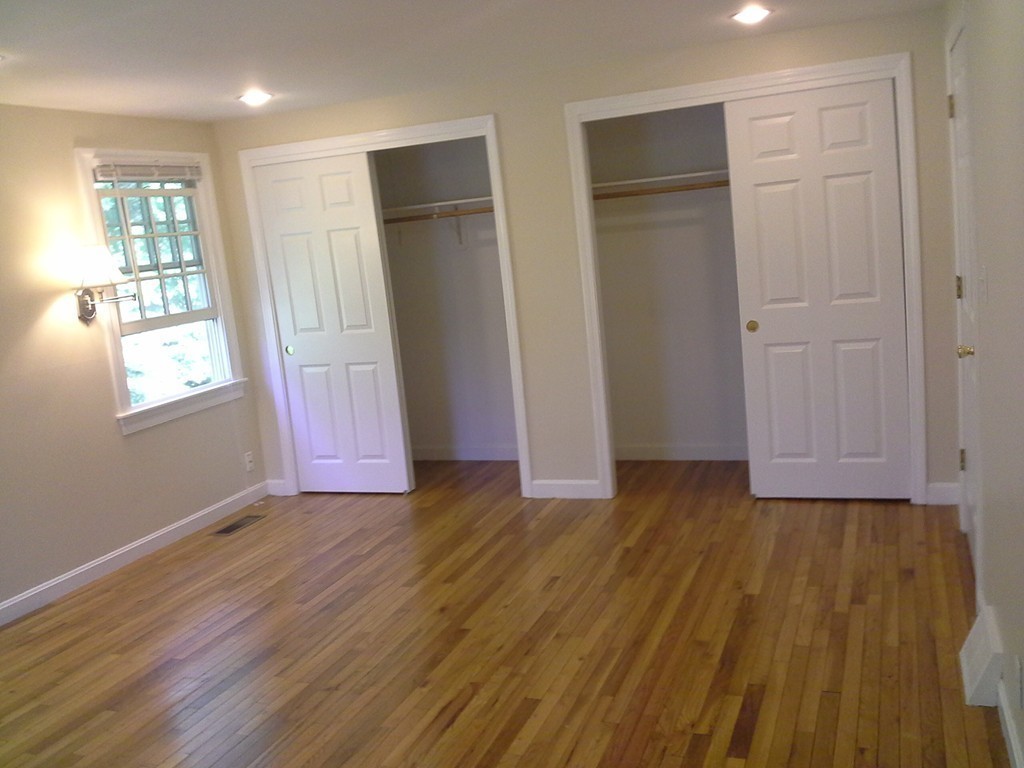123 Jericho Road, Unit 123 Weston, MA 02493 - Photo 8 of 12 an empty room with wooden floor and windows